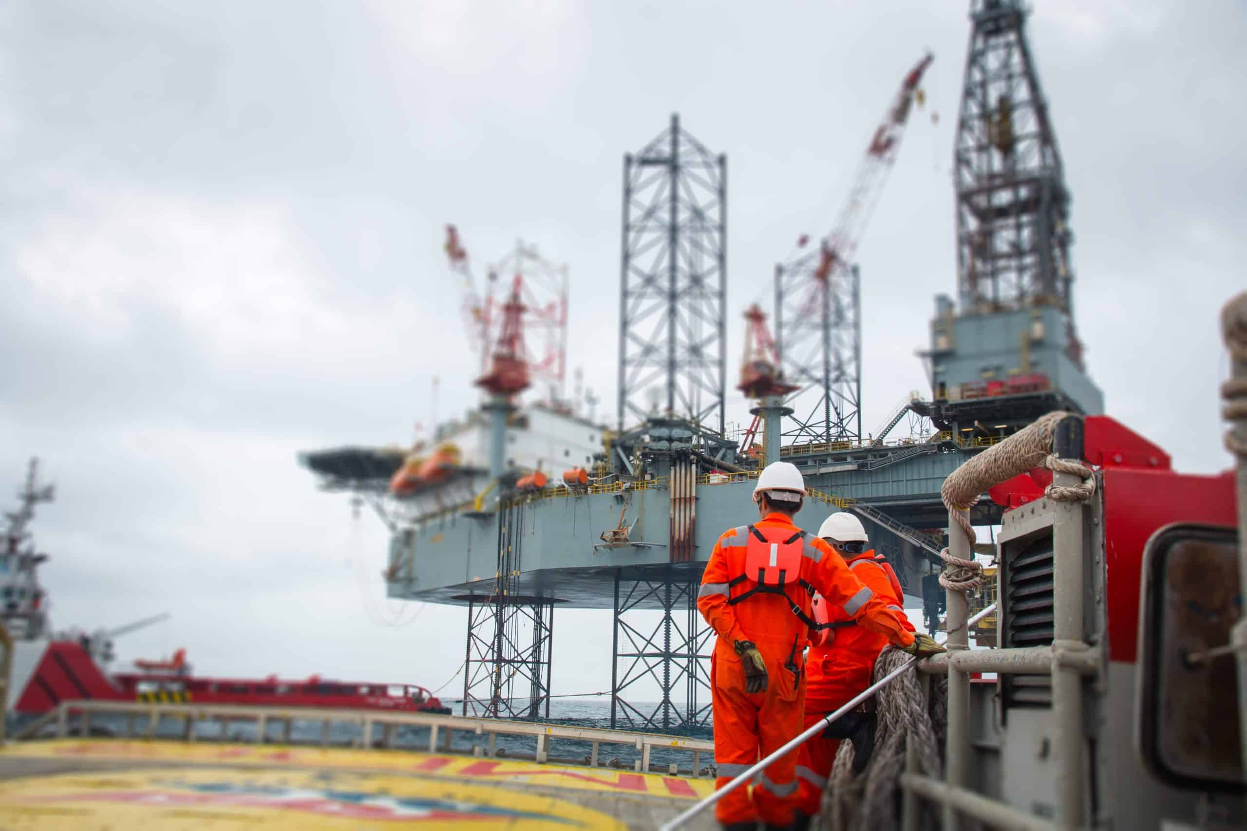Two workers stood on an oil rig