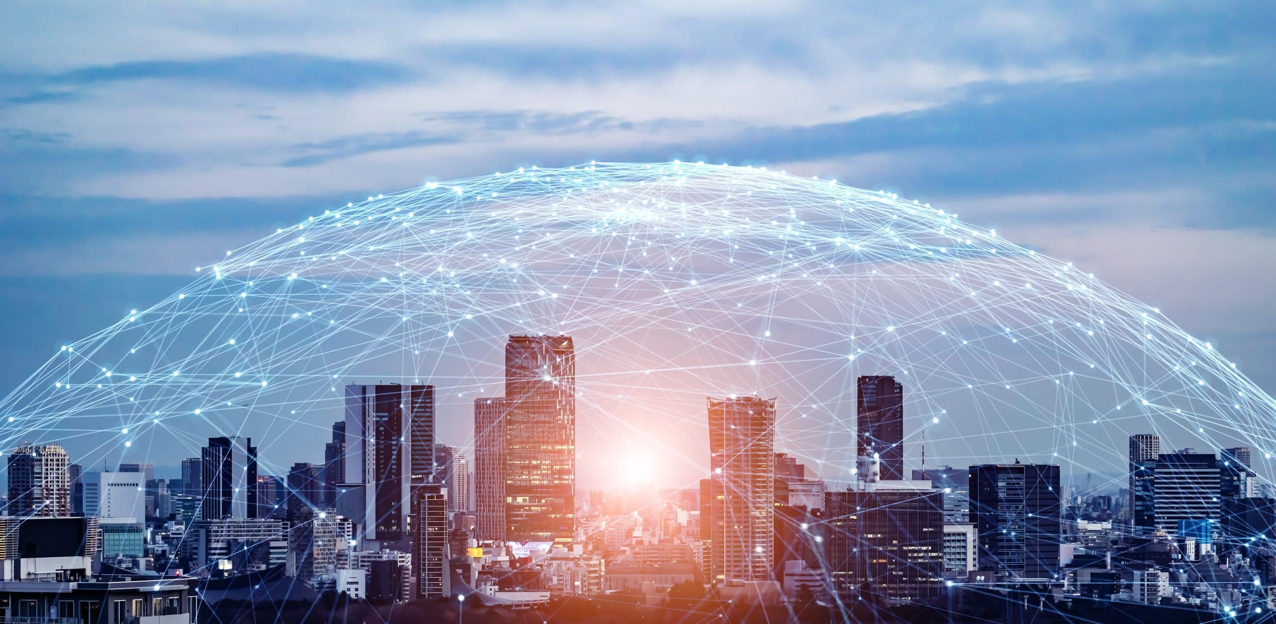 City skyline with digital network connections forming a dome over the buildings at sunset.