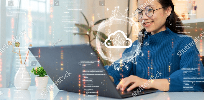 Woman using a laptop with cloud data migration graphics overlayed.