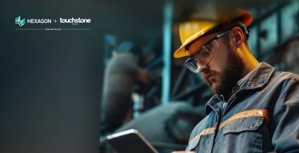 A worker in safety gear uses a tablet, with Hexagon and Touchstone logos in the corner.