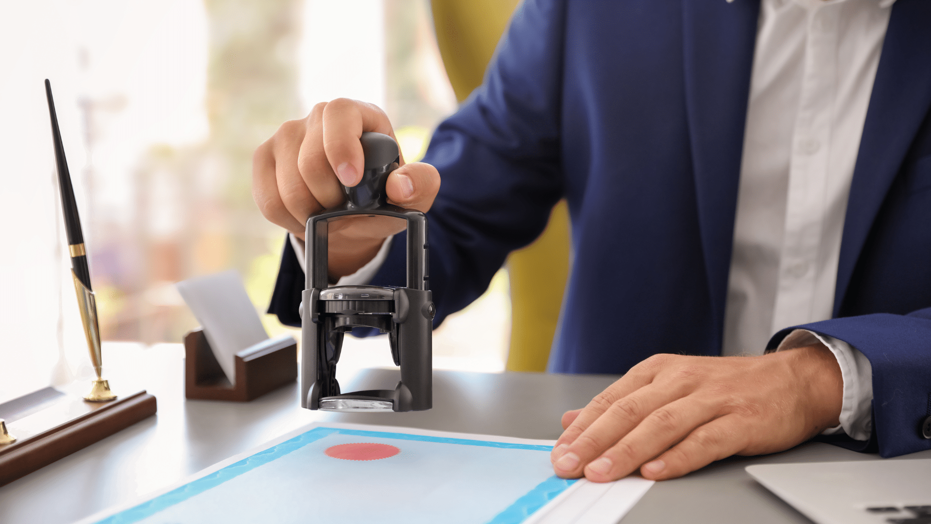 Website blog covers – Energy (15) Person in a suit stamping a document at a desk.