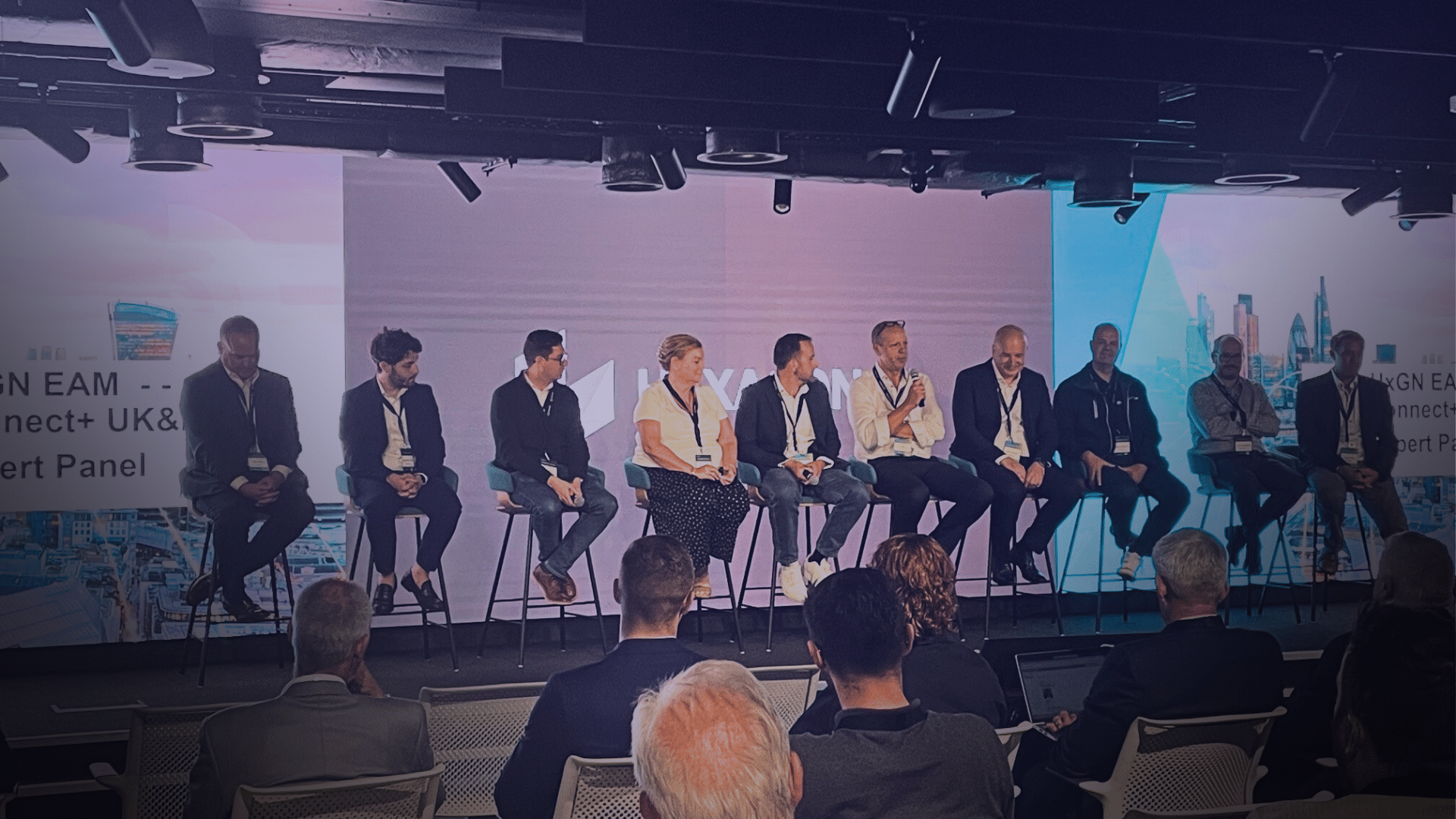Website blog covers – Energy (19) A panel of speakers sits onstage at a conference in front of an audience.