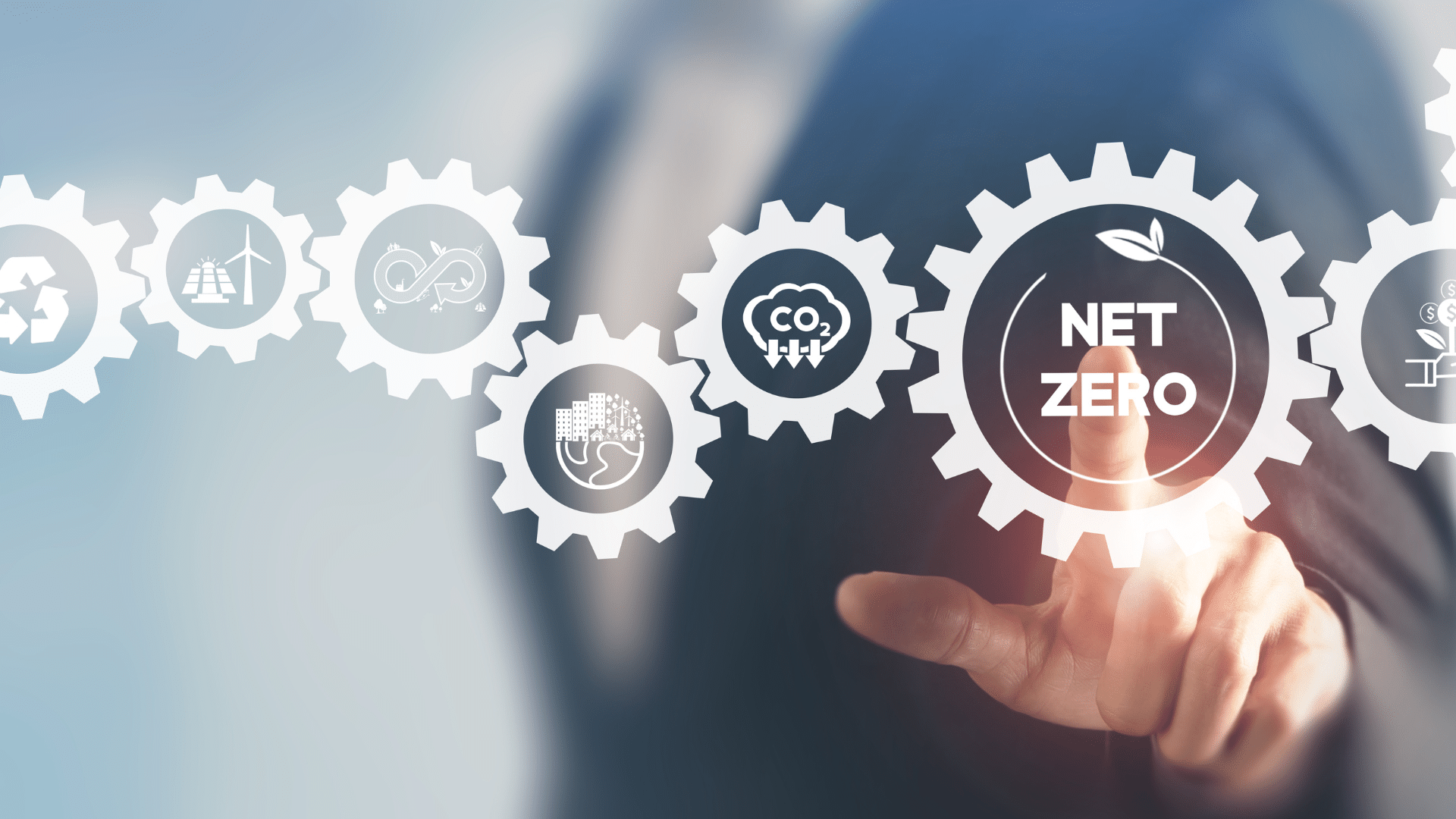 A hand points to a gear labeled "Net Zero" surrounded by sustainability-related icons.