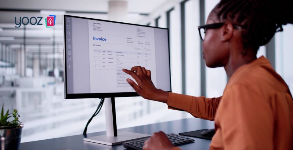 Person using a touchscreen computer to view or process an invoice in an office environment.